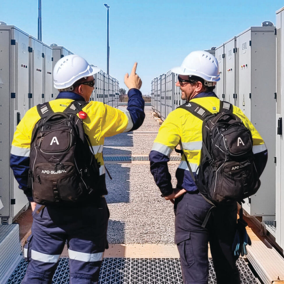 Two engineers between rows of battery enclosures at the Port Hedland 35 MW BESS