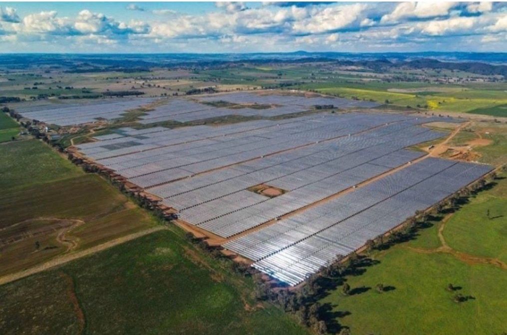 Aerial view of a utility-scale solar array surrounded by farmland