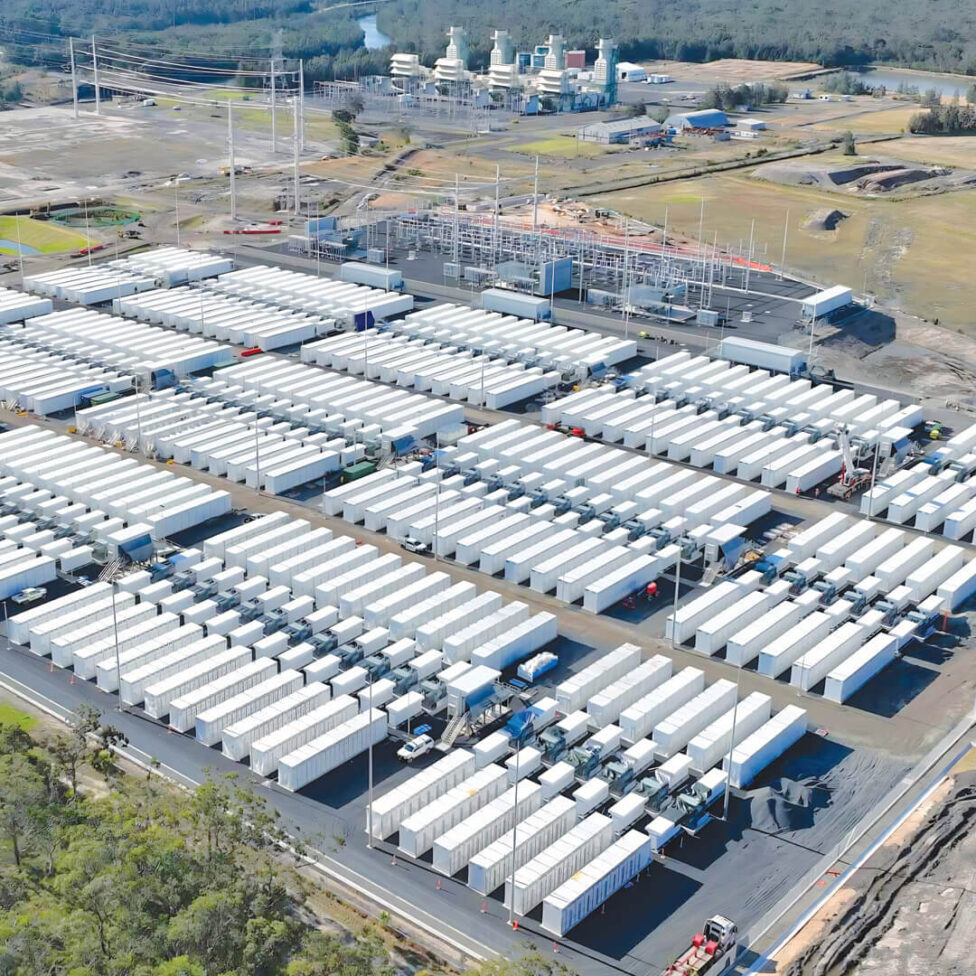 Aerial view of the Waratah Super Battery at Munmorah - rows of battery units beside the high-voltage switchyard